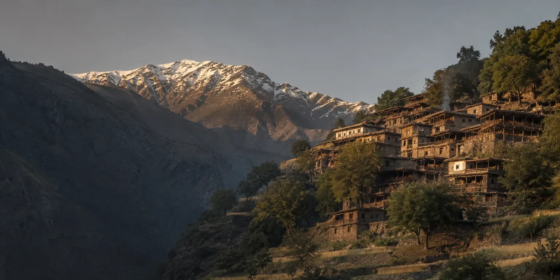 The Bumburet valley in late afternoon, Kalash timber houses stacked up the hillside among walnut trees.