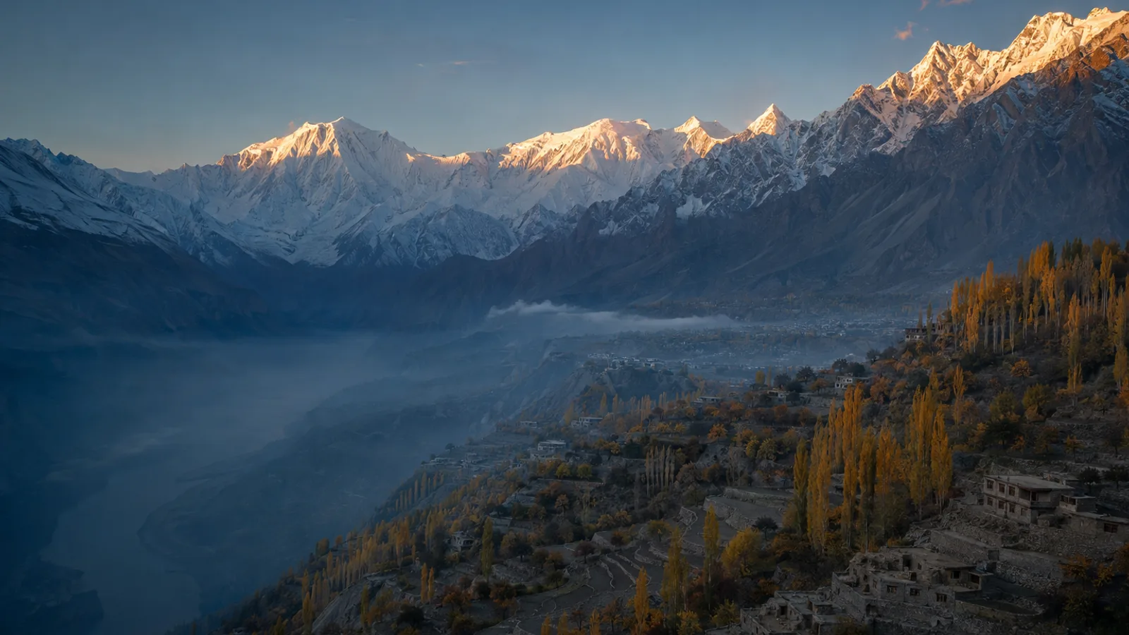 The Hunza valley from Duikar at sunrise in late October, autumn poplars below a lit wall of Karakoram snow peaks.