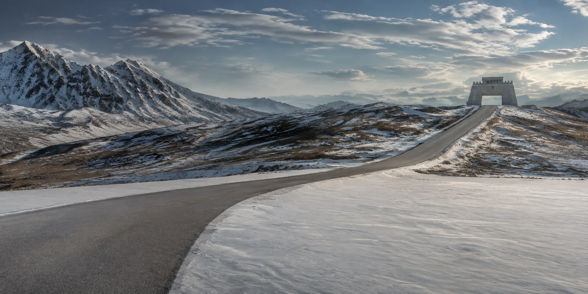 The Karakoram Highway climbing across snow-streaked slopes towards the border gate at Khunjerab Pass, 4,693 metres.