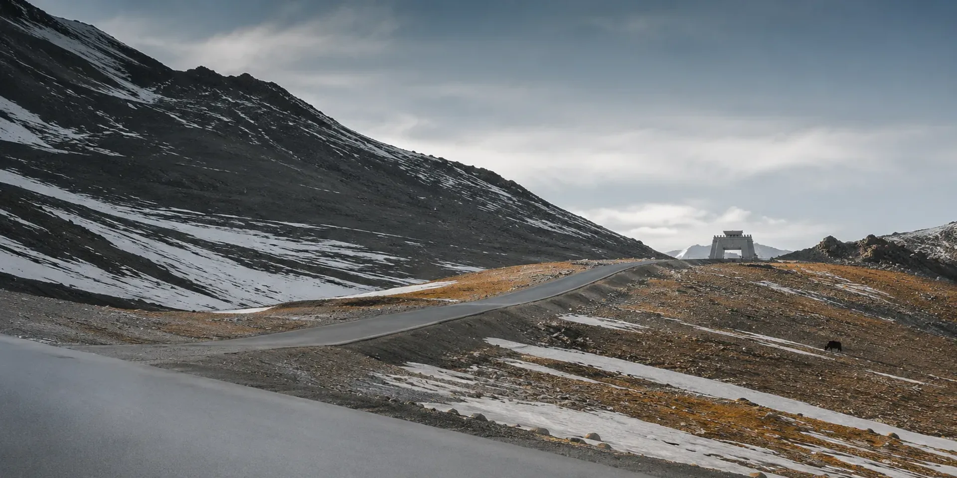 The road climbing across snow-streaked scree towards the Khunjerab saddle at 4,693 metres.