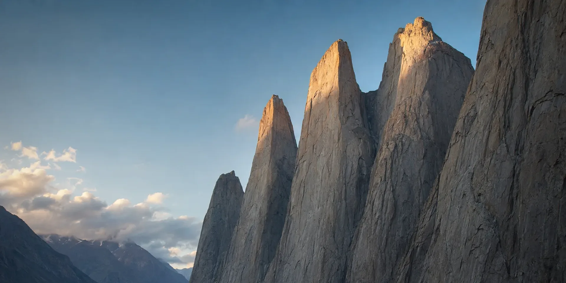 The granite towers of Nangma Valley rising straight off the green meadow of Mingulu Broq in evening light.